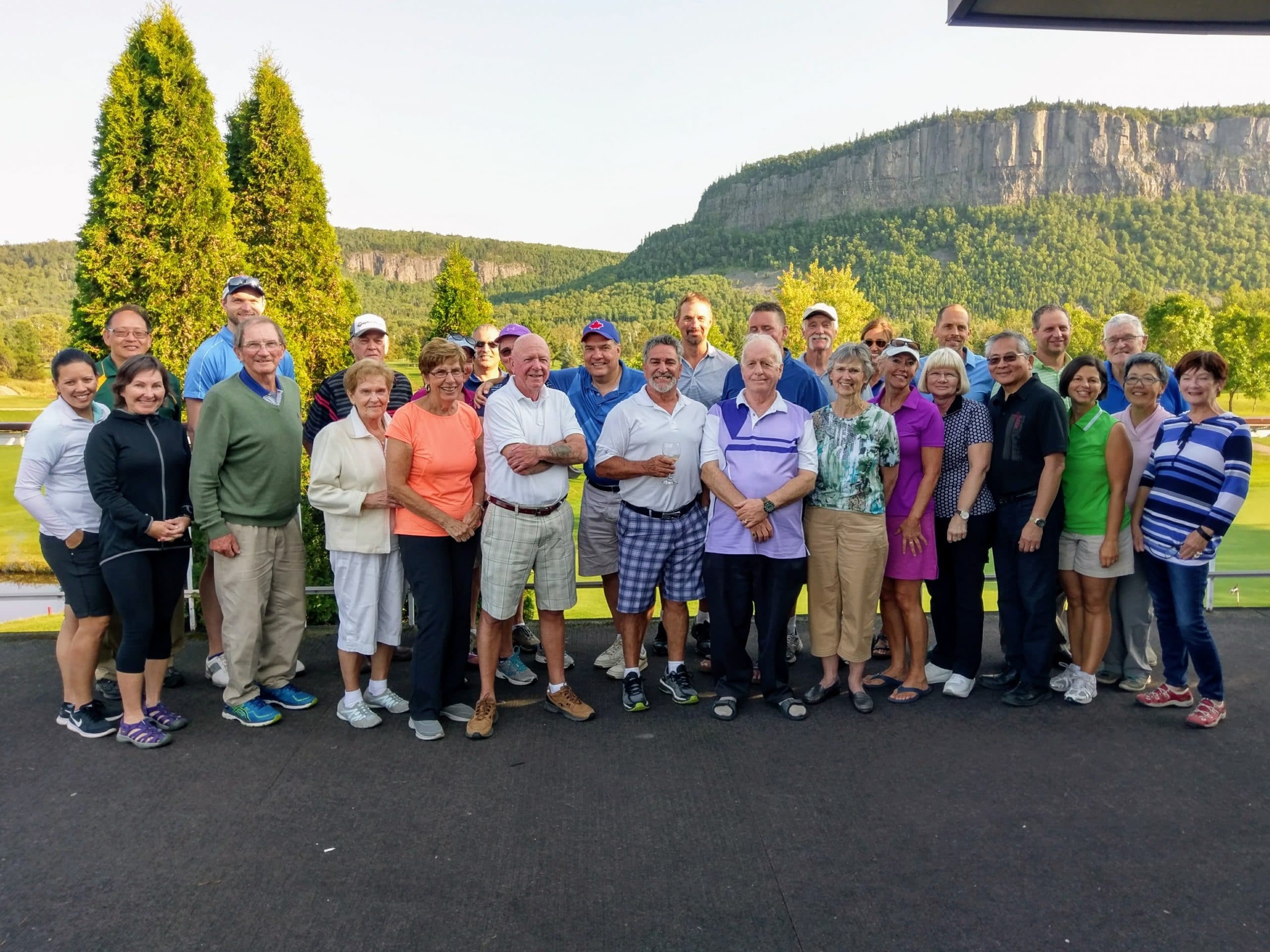 Group of people at a golf course with Mount MacKay in the background